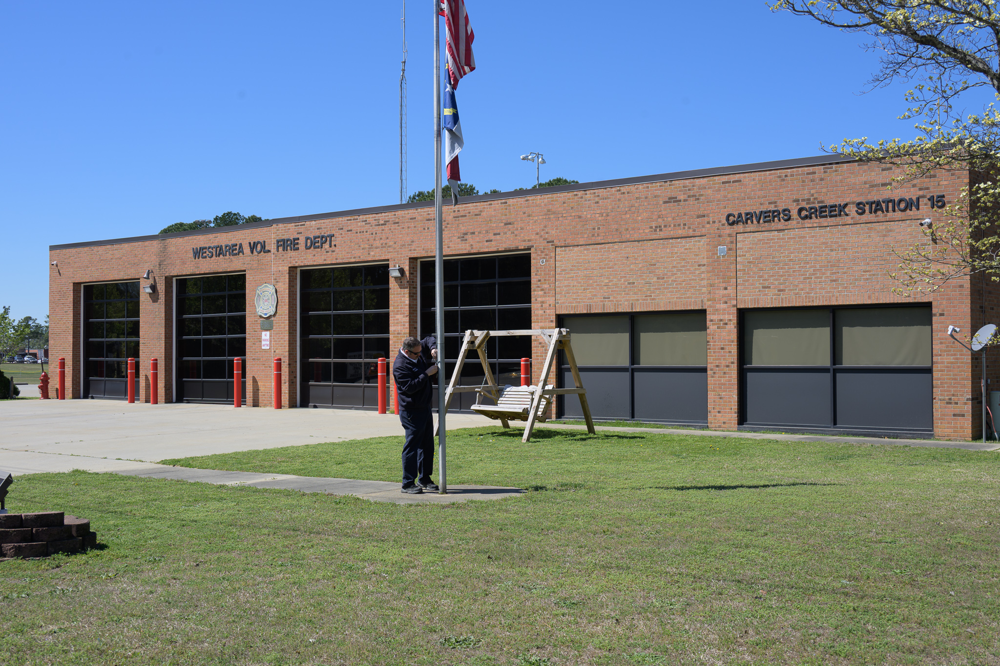 Firefighter raising flag at station